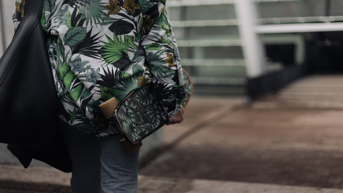 person in green white and black floral long sleeve shirt and blue denim jeans