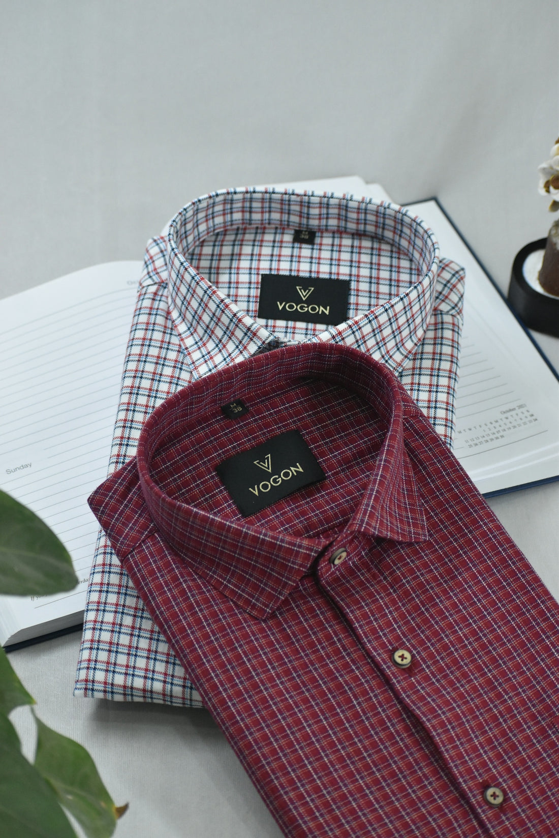 two men's shirts sitting on top of a table