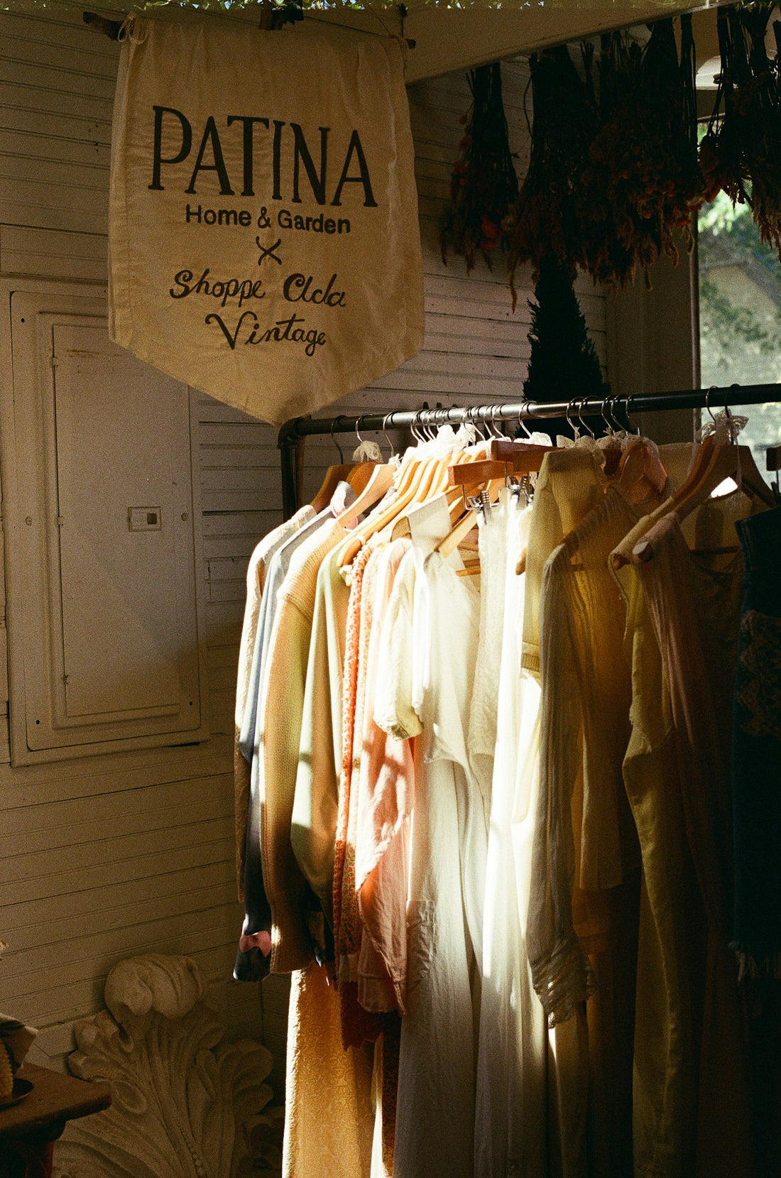 A rack of clothes in front of a window