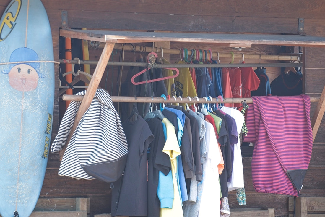 Surfboard and clothes hanging on a rack outdoors rack